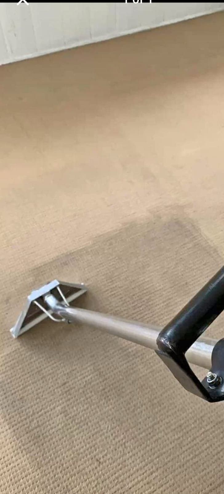 Close-up of a carpet cleaning wand extracting dirt from carpet fibres